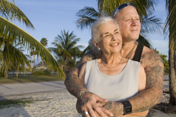 Mother and tattooed son hugging at the beach