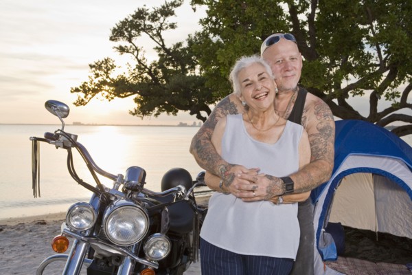 Mother and tattooed son camping at the beach