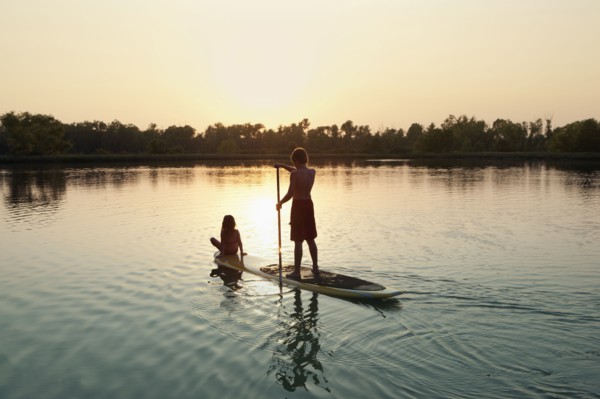 Caucasian boy and girl on paddleboard on lake