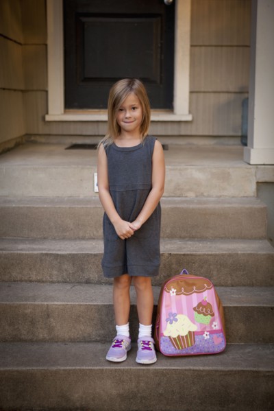 Caucasian girl with backpack on front steps