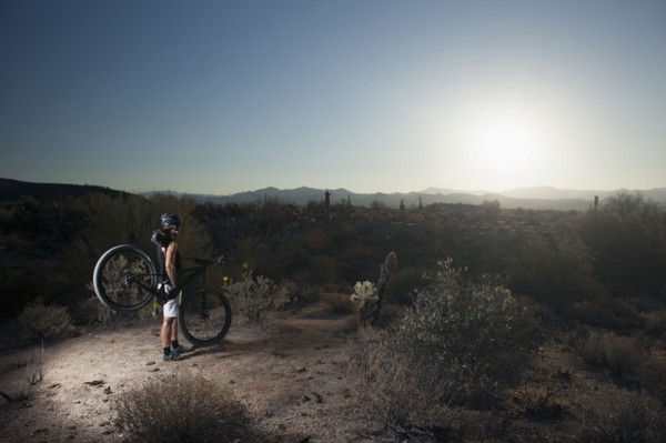 Mountain biker standing in desert