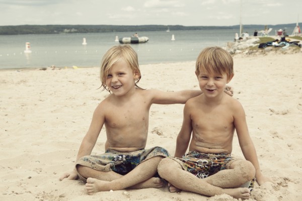 Caucasian brothers hugging on beach