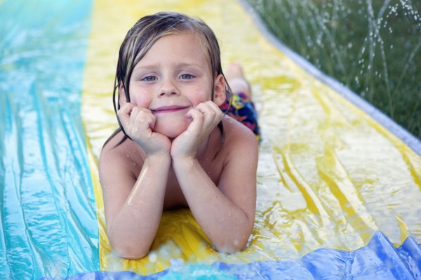 Caucasian boy smiling on water slide