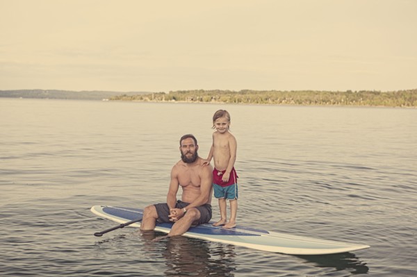 Caucasian father and son on paddleboard in lake