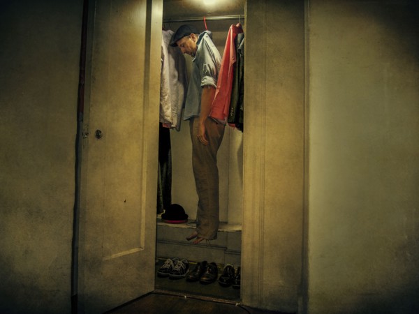 Caucasian man hanging with clothing in closet