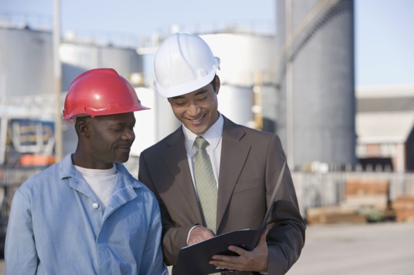 Multi-ethnic businessman and construction worker looking at paperwork