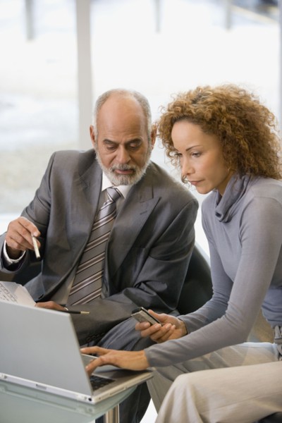 African businesspeople looking at laptop