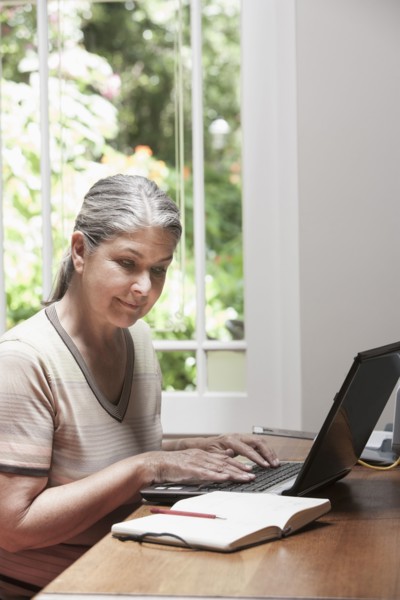 Caucasian woman transcribing journal