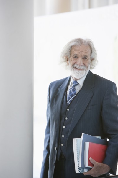 Senior Caucasian businessman carrying books
