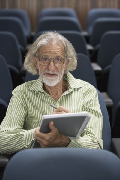 Senior Caucasian student taking notes in classroom