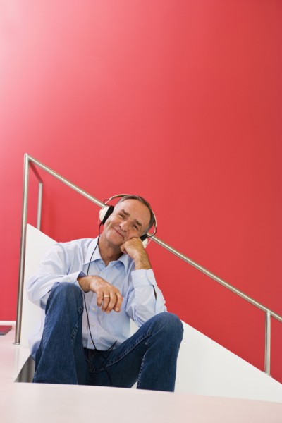 Man listening to headphones on stairs