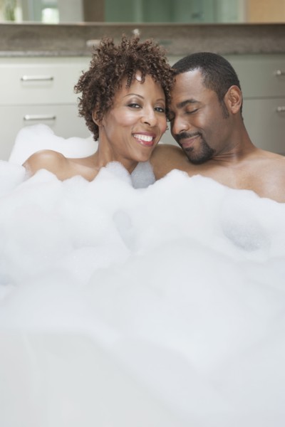 African American couple relaxing in bath