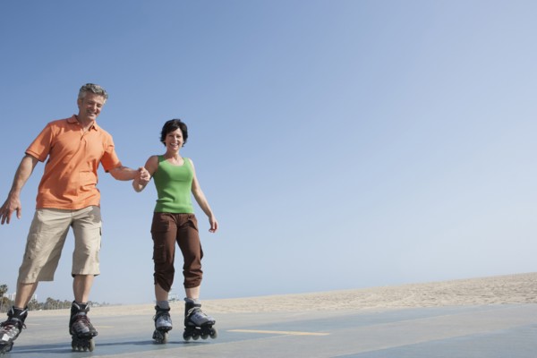 Caucasian couple rollerblading by beach
