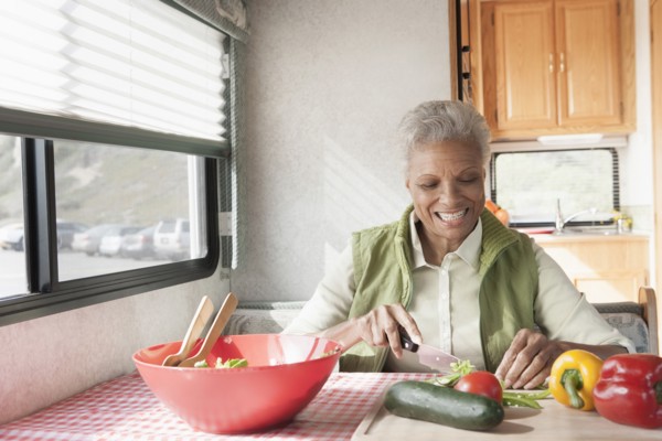 Mixed race Senior woman cooking in RV
