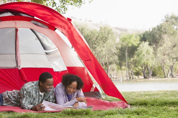 Couple reading newspaper together in tent