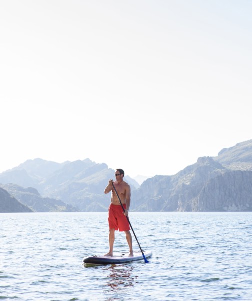 Hispanic man on paddleboard in river