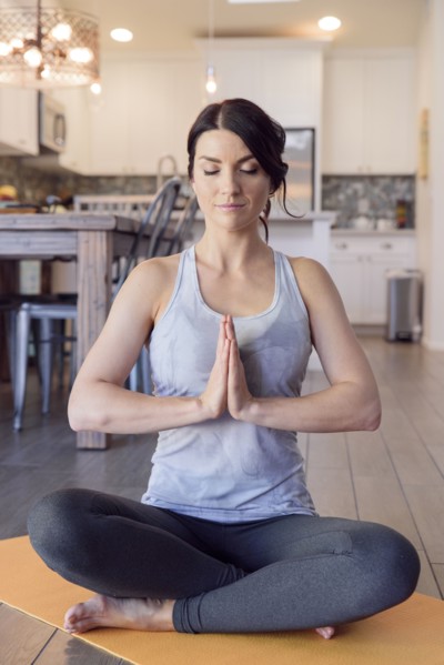 Caucasian woman performing yoga and meditating