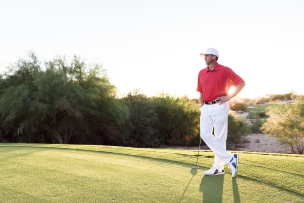 Hispanic golfer waiting on golf course