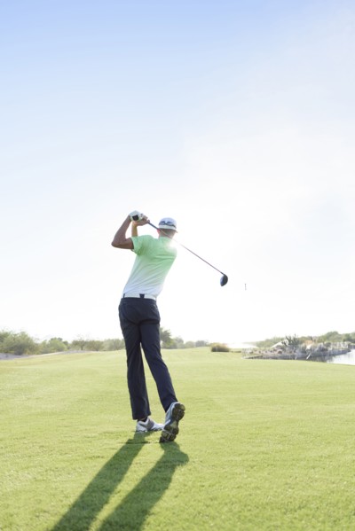 Caucasian man teeing off on golf course