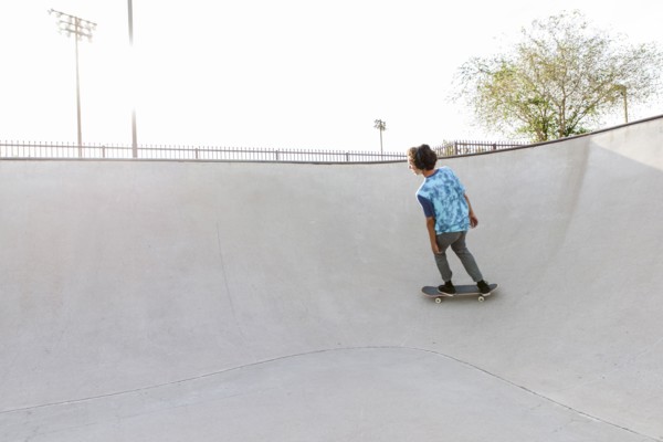 Hispanic man riding skateboard on ramp