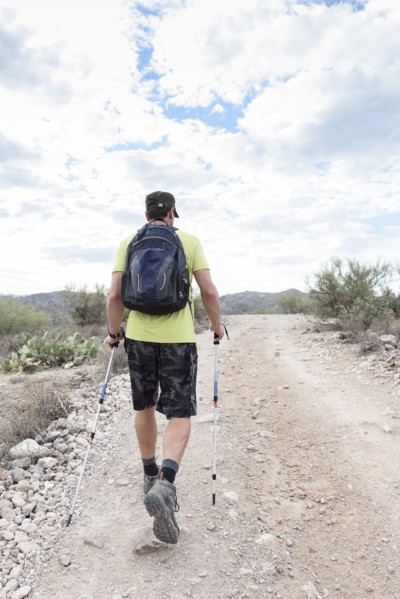 Hispanic man hiking on rocky path in desert