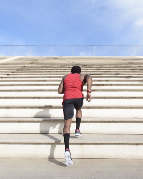 African American man running on bleachers