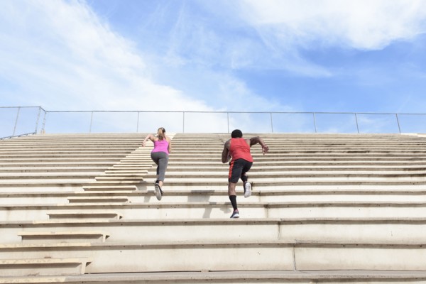 Man and woman running on bleachers