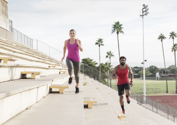 Man and woman running on bleachers