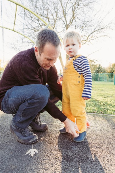 Caucasian father adjusting pants for son