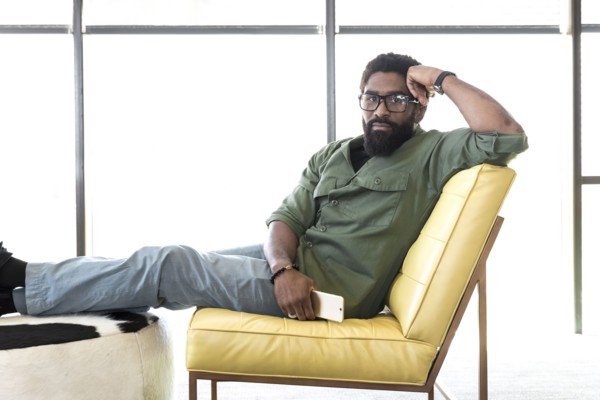 Black man sitting in chair holding cell phone