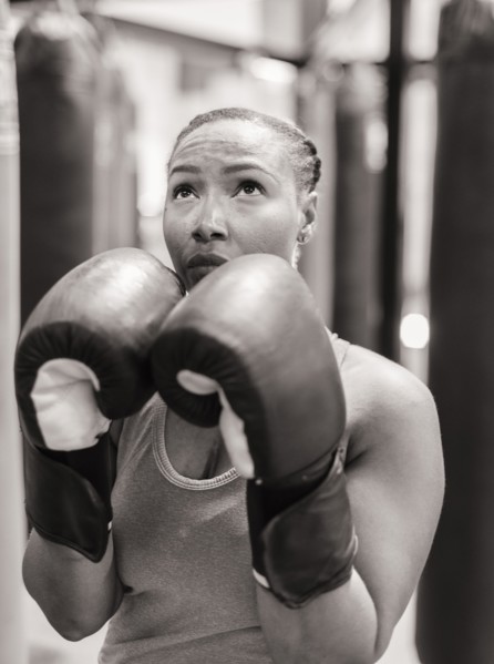 Portrait of Black woman wearing boxing gloves looking up