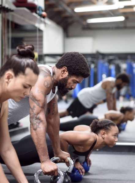 Man and women doing push-ups with kettlebells
