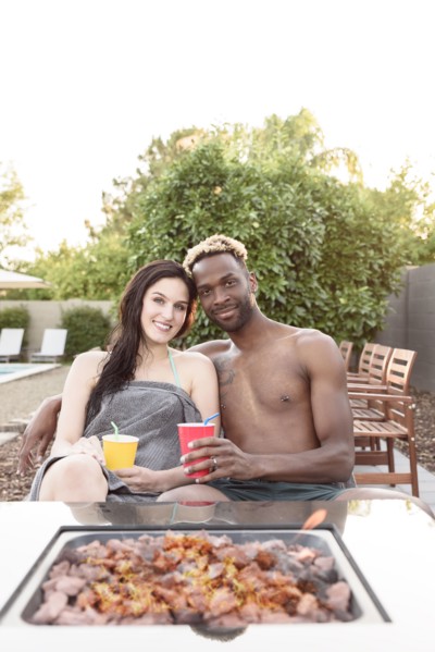 Portrait of smiling couple wrapped in towels near fire pit