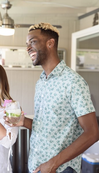 Man holding cold drink laughing outdoors
