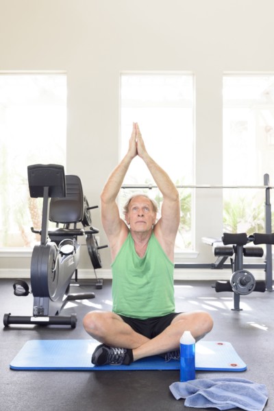 Caucasian man practicing yoga in gymnasium