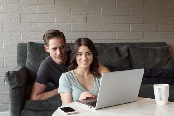 Caucasian couple on sofa using laptop