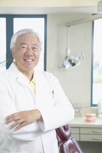 Senior Asian male dentist smiling