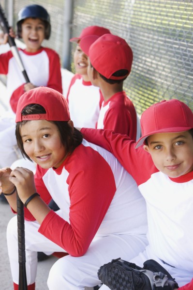 Multi-ethnic boys in baseball uniforms in dugout