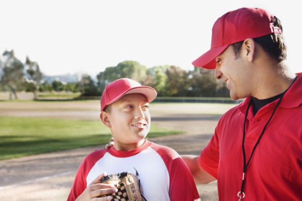 Hispanic baseball player and coach talking