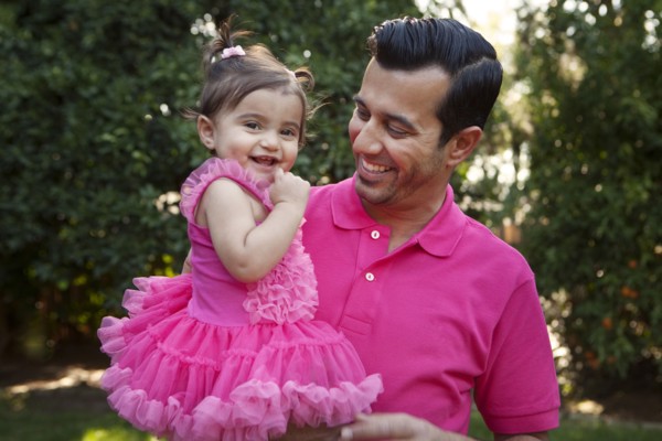 Father holding daughter in backyard