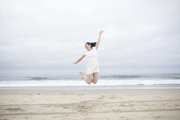 Woman jumping for joy on beach