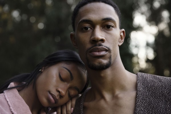 Woman resting head on shoulder of man