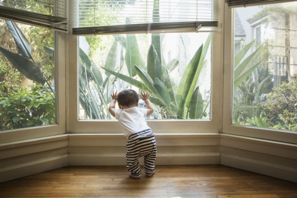 Baby boy looking out window
