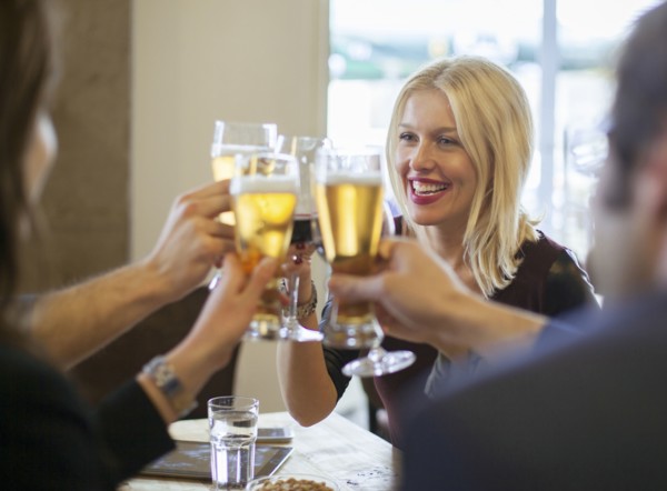 Friends toasting with beer in cafe