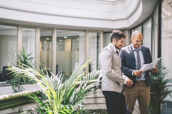 Caucasian businessmen reading paperwork on office balcony