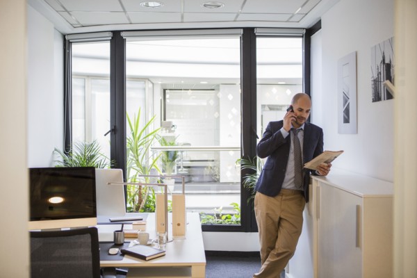 Caucasian businessman talking on cell phone in office