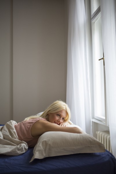 Smiling woman laying in bed