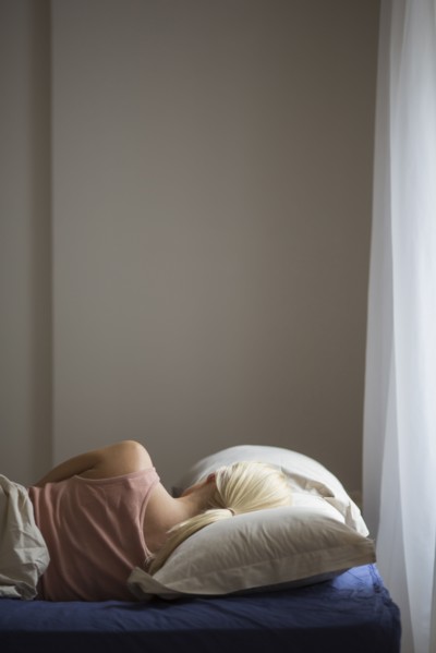 Rear view of woman sleeping in bed
