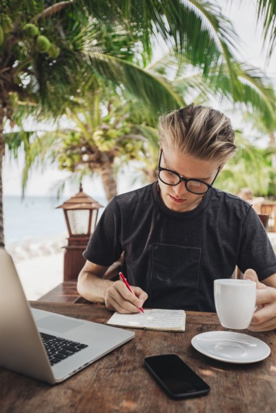 Caucasian man writing in cafe