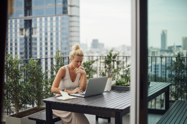 Caucasian woman using laptop on balcony